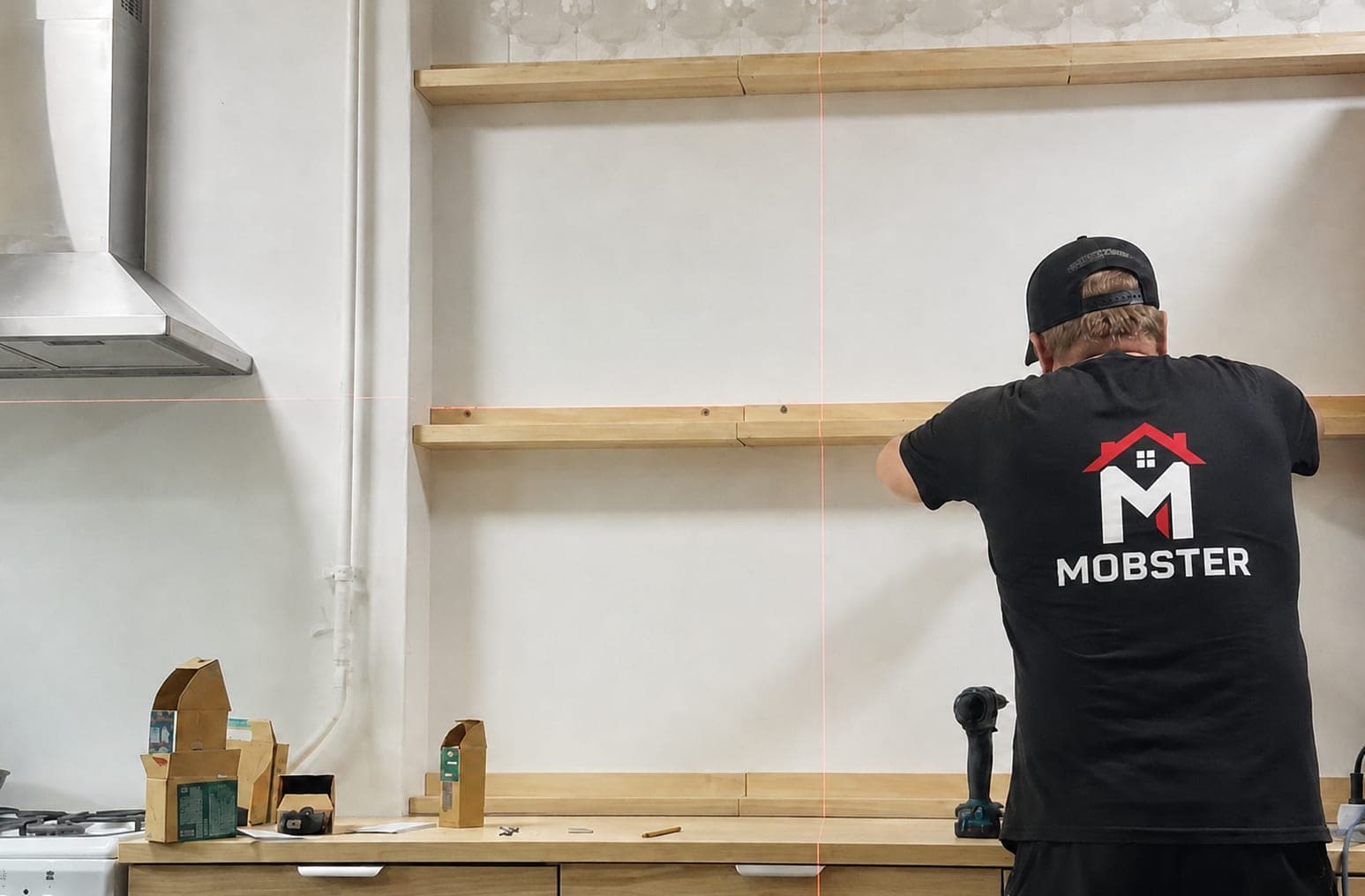 A Mobster levelling floating kitchen shelves against a laser line